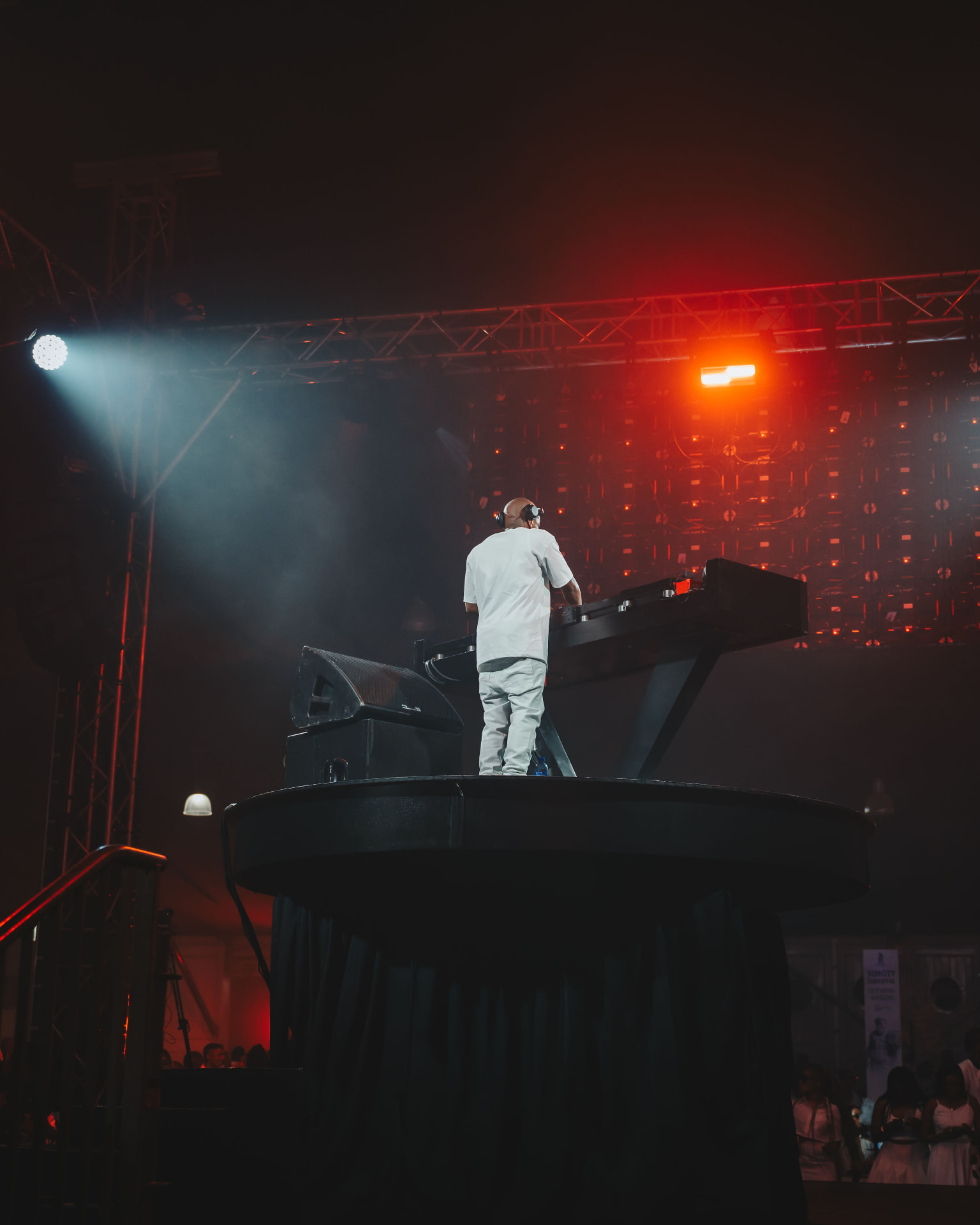 DJ on a raised stage under red and blue lights